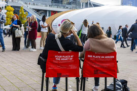 Frauen sitzen auf Stühlen auf der Agora