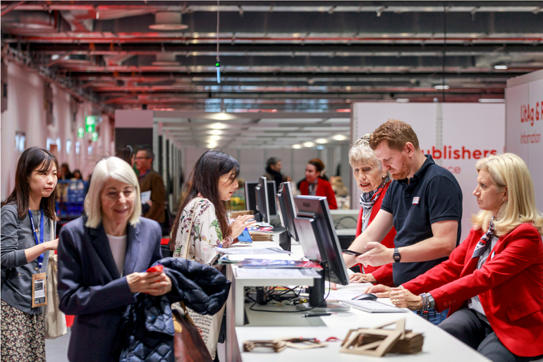 Fachbesucher:innen an der Anmeldung