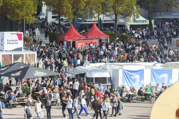 Eine große Ansammlung von Menschen auf der Freifläche zwischen den Messehallen