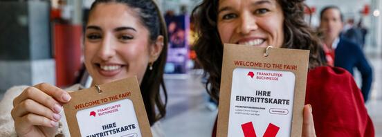 Zwei Frauen zeigen ihr Ticket für die Frankfurter Buchmesse 