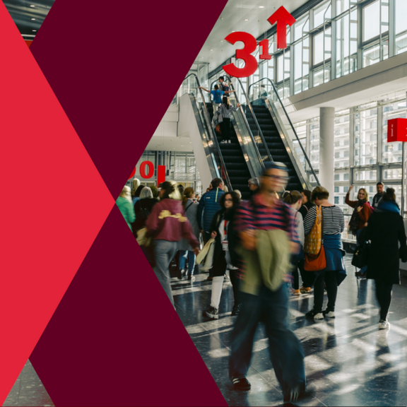 Menschen gehen in einer Halle in verschiedene Richtungen. 